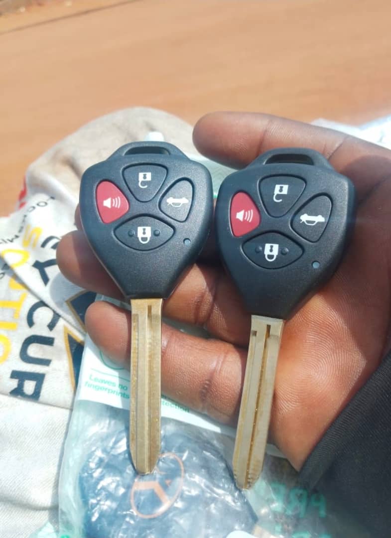 Two spare car remote keys held in hand